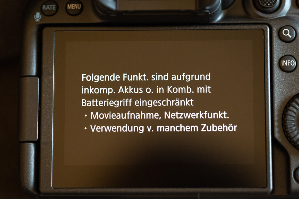 Bildschirm der Canon R5 Mark II mit der Anzeige Folgende Funk. sind aufgrund inkomp. Akkus o. in Komb. mit Batteriegriff eingeschränkt - Movieaufnahme, Netzwerkfunkt. - Verwendung v. manchem Zubehör  - Anzeige bei der Verwendung des Canon Batteriegriffs BG-R10